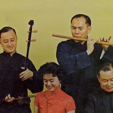 Four people playing Chinese musical instruments.