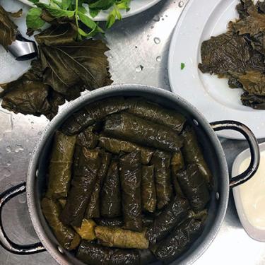 Attractively arranged in a circular pot is a pile of Yalanchi, a traditional Armenian dish of rice wrapped in grape leaves.