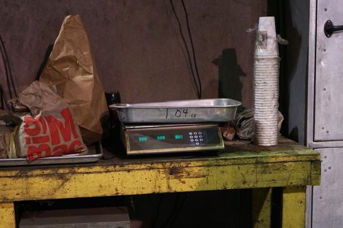A metal tray sits on top of a scale. To the tray’s left is a Big Mac bag and to its right is a stack of foam coffee cups. 