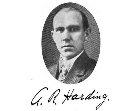 Portrait of a man wearing a suit in an oval shaped frame. Black and white. Black handwritten signature underneath the portrait: A.R. Harding. 