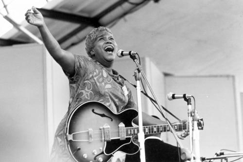 Black and white photograph of Sister Rosetta Tharpe singing and holding a guitar.