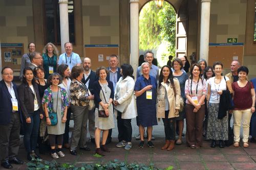 A group of people with conference badges standing in front of an archway.