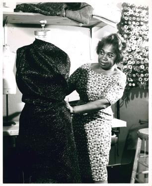 Designer Zelda Wynn Valdes demonstrates the draping on a dress form. 