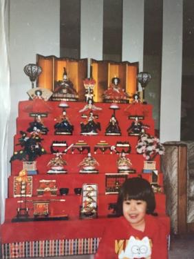 Five-year-old Christine posing in front of her mother&rsquo;s doll display for Hinamatsuri.