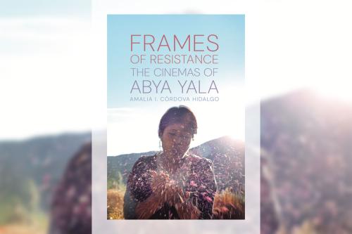 Book cover with title: Frames of Resistance: The Cinemas of Abya Yala. Underneath the text, photo of a woman blowing pink flower petals or other plant matter toward the camera, as the sun peaks behind a mountain in the background.