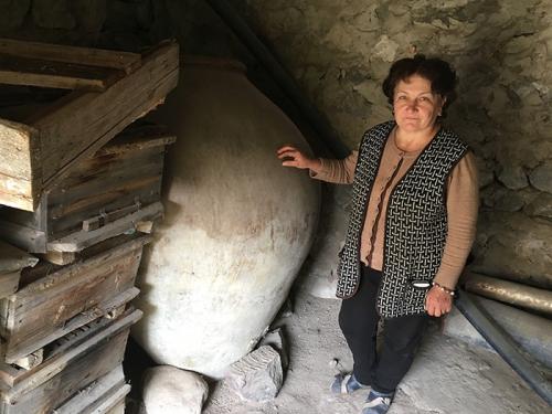 Asli Saghatelyan stands next to her father-in-law’s 240-gallon karas, a clay vessel traditionally used in Armenia, until recently, for storing and fermenting homemade wine. Photo by Karine Vann, Smithsonian