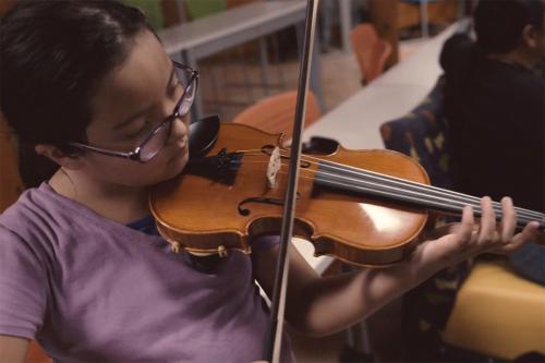 A Heartbeat Project student practices her violin in the hoogan (Diné family home) at Navajo Technical University. Photo by Charlie Weber