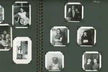 A spread in a photo album with black pages and small black-and-white portraits of people mounted inside.